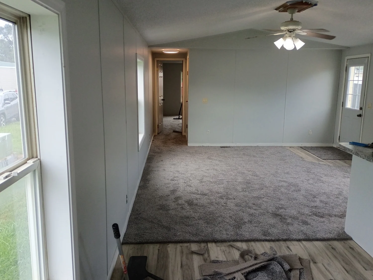 New carpet installed in a living area, with finishing work in progress