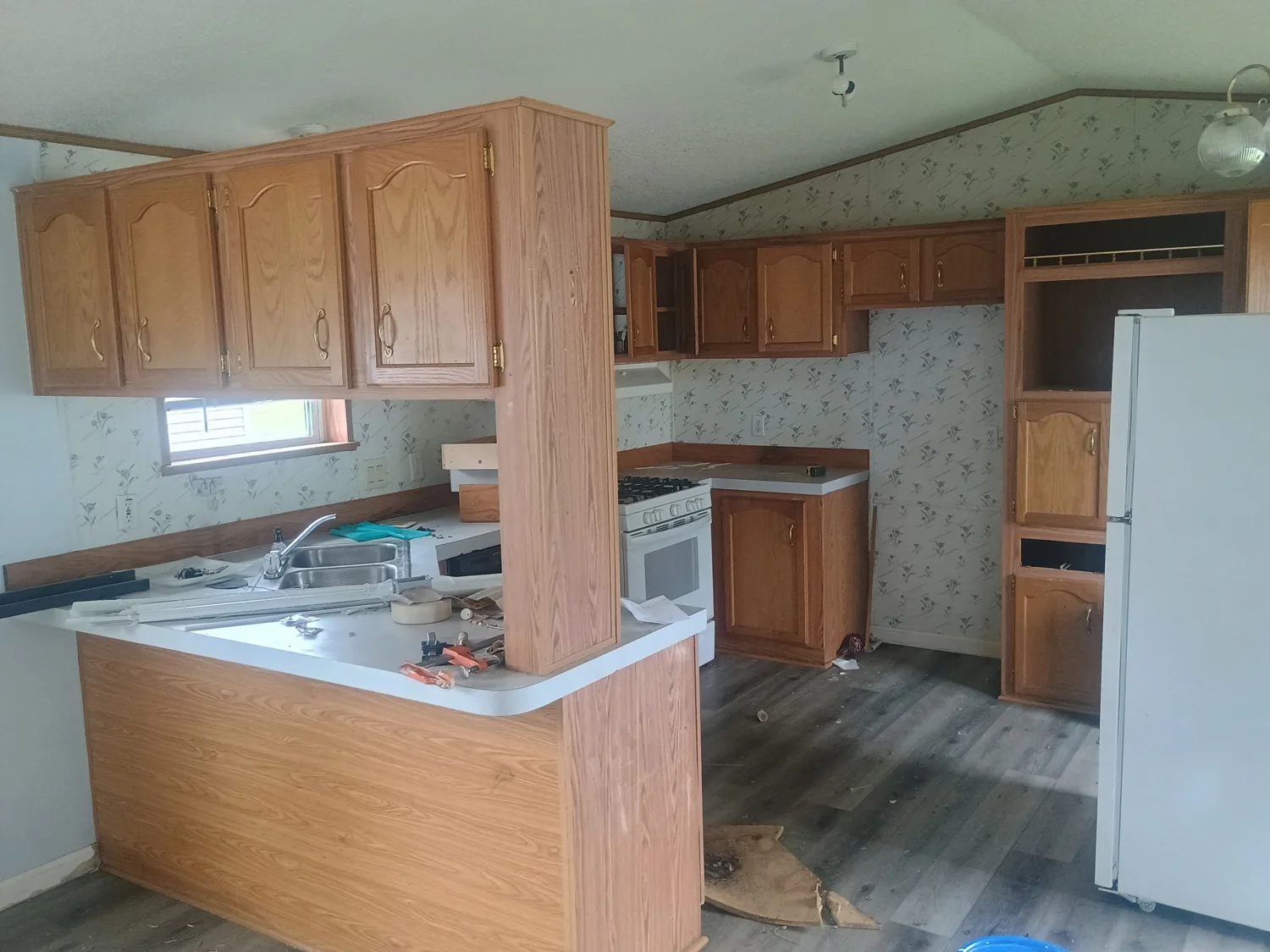Kitchen before remodeling, with original wood cabinets