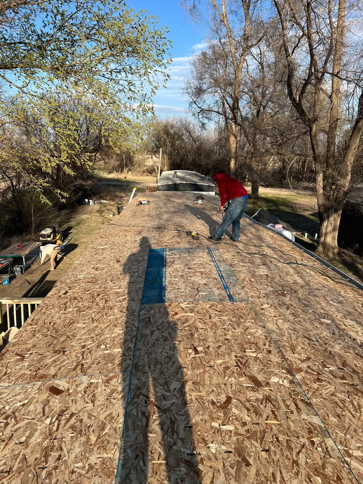 New OSB sheathing installed across the mobile-home roof during wind-damage repairs.