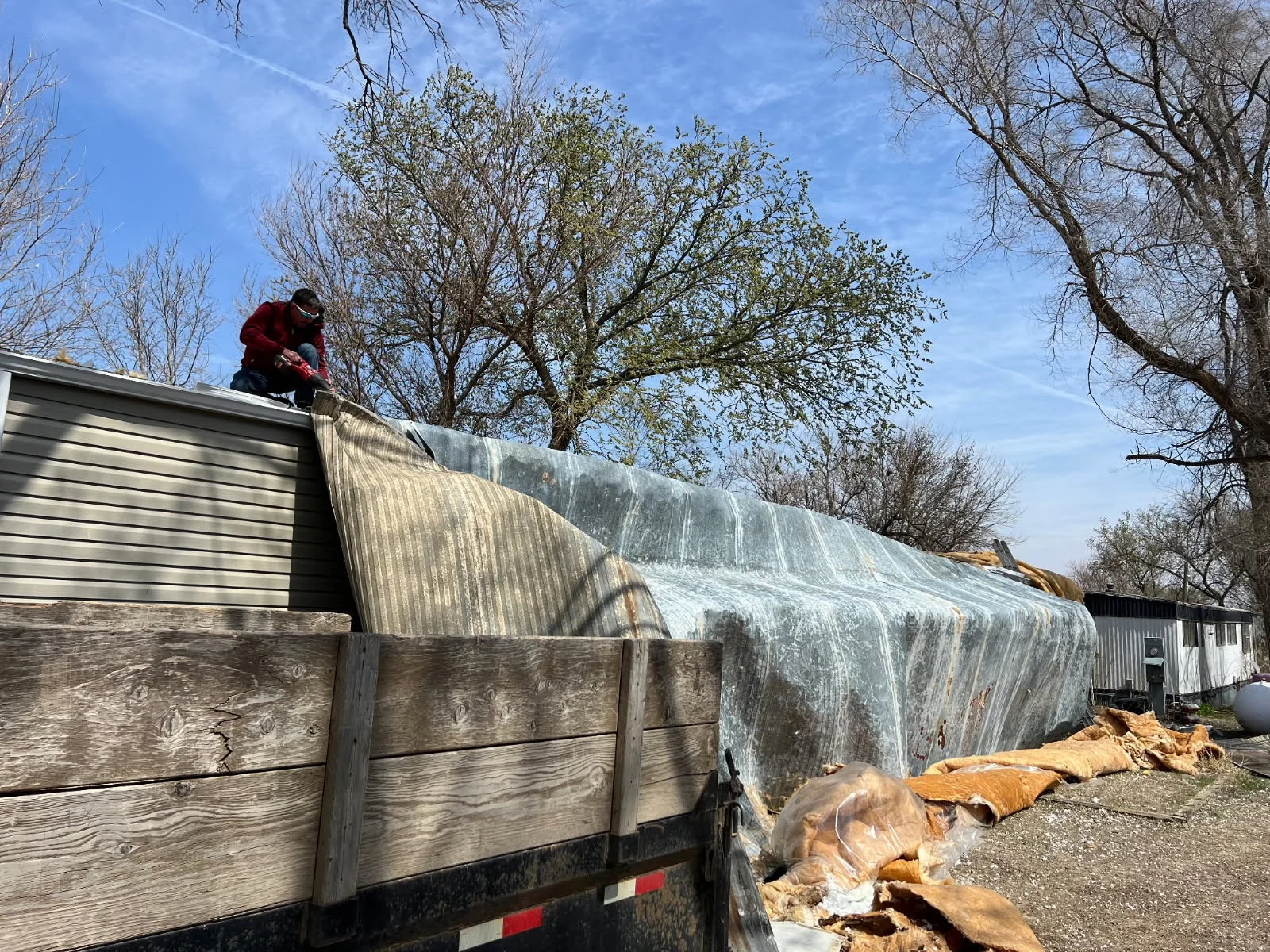 Repair work on a mobile home after wind tore away part of its roof.